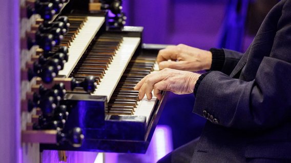 Nahaufnahme von H&auml;nden, die auf einer Orgel spielen. 