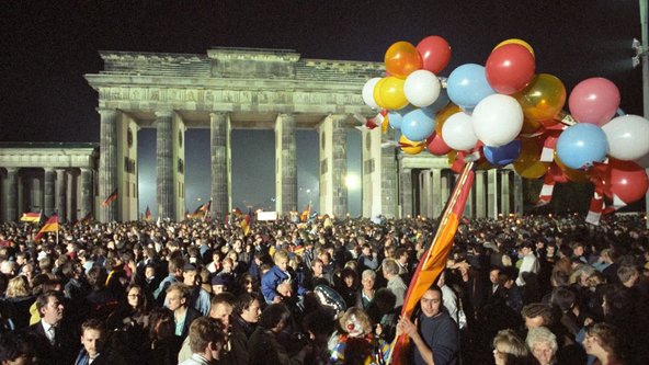 Ausgelassen feiert eine riesige Menschenmenge in der Nacht vom 2. auf den 3. Oktober 1990 vor dem Brandenburger Tor in Berlin 