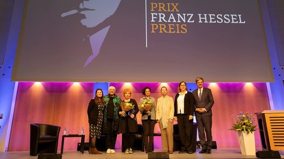 Kulturstaatsministerin Claudia Roth auf der Bühne mit den Preisträgerinnen des Franz-Hessel-Preises.