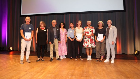 Gruppenfoto von Kulturstaatsministerin Roth mit den drei Preisträgerinnen und Preisträgern des Spitzenpreises und Jurymitgliedern bei der Verleihung.
