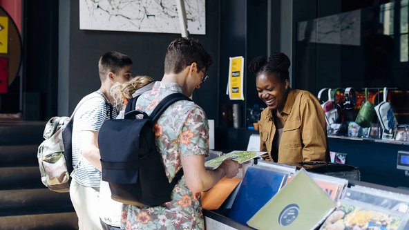 Vier Jugendliche stöbern durch eine Schallplattensammlung.