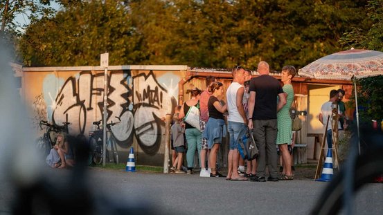 Eine Gruppe von Menschen unterhält sich im Garagenhof Harthweg.