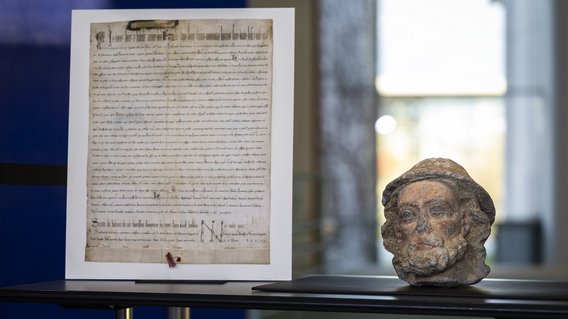 Eine Deutschordensurkunde (Faksimile) sowie der Kopf des Heiligen Jakobus des &Auml;lteren.