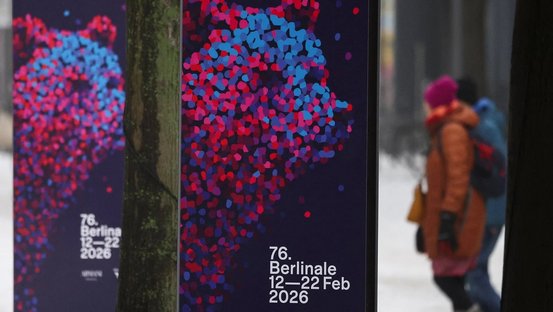 Berlinale-Plakate am Potsdamer Platz mit Passanten im Schnee