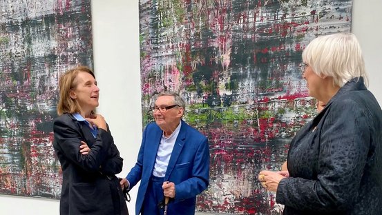 Kulturstaatsministerin Roth unterhält sich vor Gerhard Richters abstrakten Birkenau-Werken mit ihrer polnischen Amtskollegin Hanna Wróblewska und Marian Turski.
