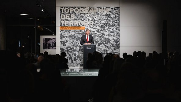 Staatsminister Weimer spricht am Rednerpult im Rahmen der Ausstellungser&ouml;ffnung