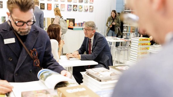 Staatsminister Weimer im Gespr&auml;ch mit Verlegerin Marlene Taschen am Messestand des Taschen-Verlags