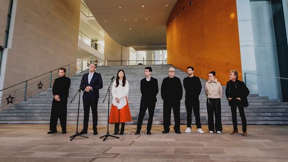 Staatsminister Weimer mit Musikerinnen und Musikern im Bundeskanzleramt