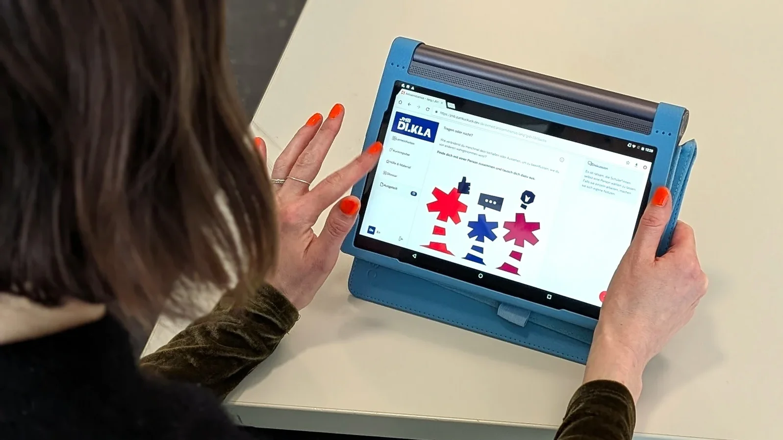Eine Person navigiert auf einem Tablet durch die Online-Plattform des J&uuml;dischen Museums Berlin.