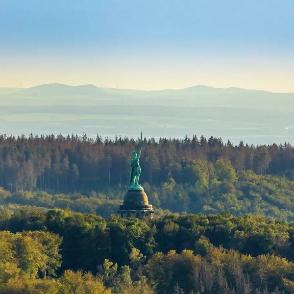 Luftbild des Hermannsdenkmals im Teutoburger Wald vor blauem Himmel.