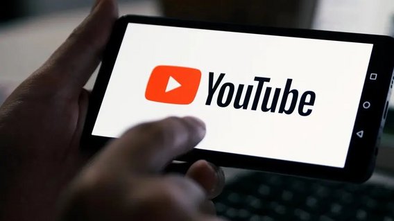 Mann h&auml;lt ein Smartphone mit YouTube-Logo auf dem Bildschirm