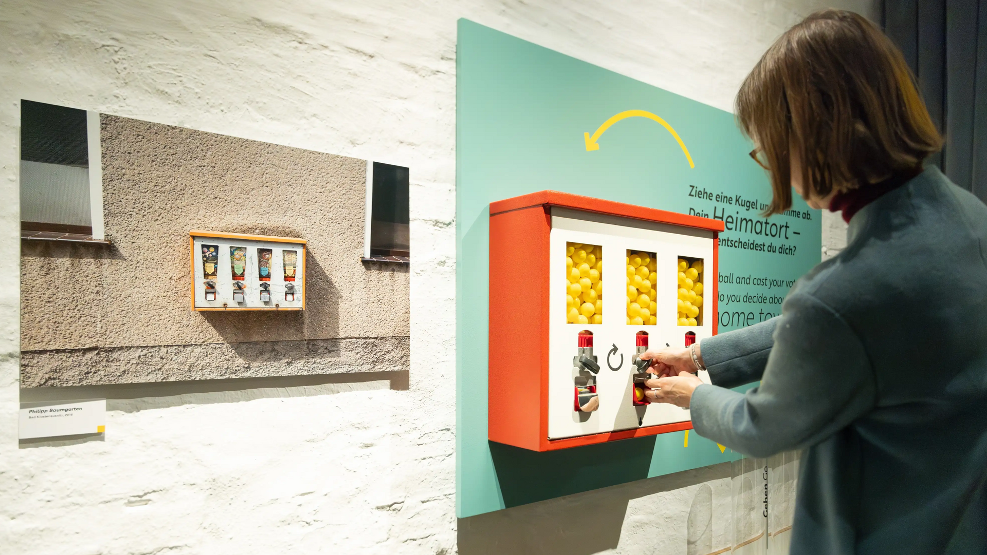 Eine Frau bedient den Kaugummiautomat in der Ausstellung "Ostblicke"