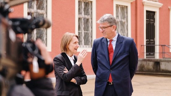 Kulturstaatsminister Wolfram Weimer unterhält sich vor dem Neuen Schloss mit der polnischen Kulturministerin Hanna Wróblewska.