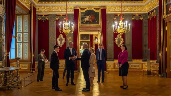 Staatsminister Weimer und Staatsministerin Klepsch werden durch das Audienzgemach mit Thron der Parader&auml;ume gef&uuml;hrt. 
