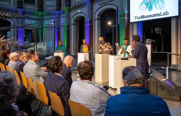 Podiumsdiskussion mit drei Stipendiatinnen und einem Stipendiat aus Europa und Afrika im Sauriersaal des Berliner Naturkundemuseums