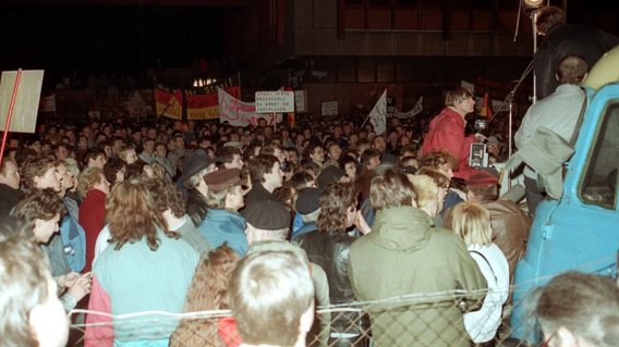 B&uuml;rgerinnen und B&uuml;rger demonstrieren im Dunkeln vor der Stasi-Zentrale in Berlin. 