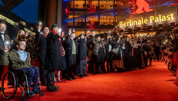 Schauspielerinnen und Schauspieler und die Berlinaleleitung protestieren auf dem roten Teppich